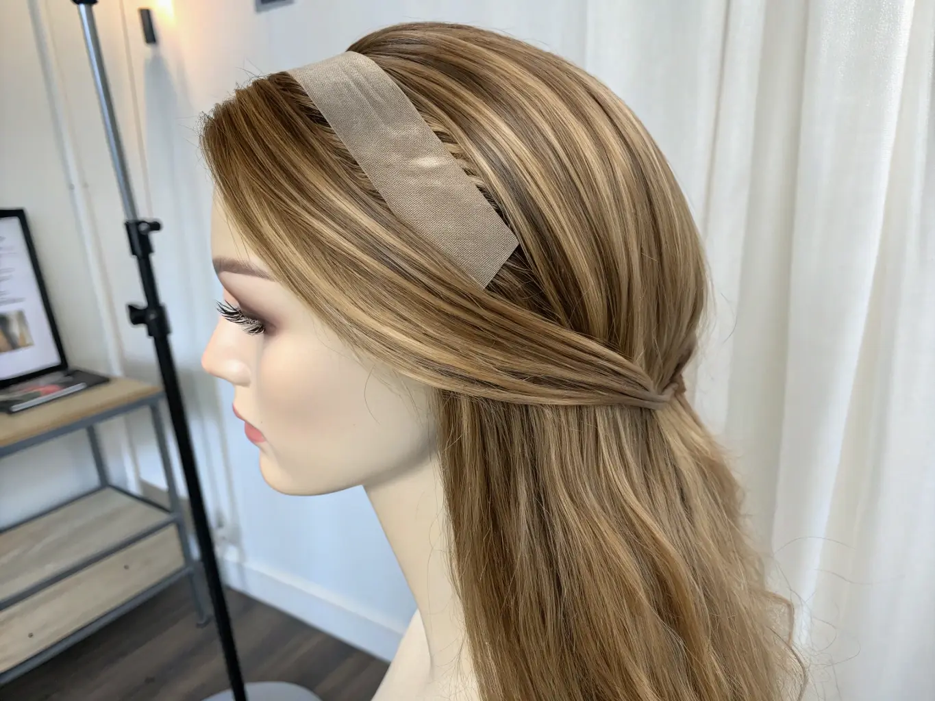 A detailed view of Silky Tape-In Extensions in Blonde Natural, highlighting the ultra-thin, discreet adhesive strips. The extensions are laid out on a white surface to showcase the seamless and natural look.